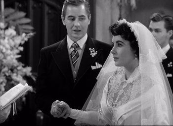 Movie still from “Father of the Bride” (1950), directed by Vincente Minnelli – A man and a woman holding hands in front of each other; Medium shot, Over the shoulder angle