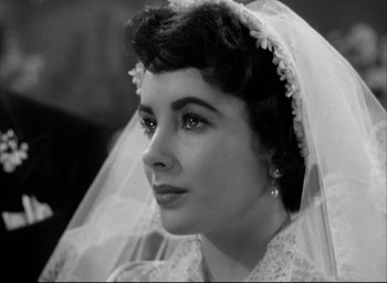 Movie still from “Father of the Bride” (1950), directed by Vincente Minnelli – A black - and - white photo of a woman wearing a wedding veil; Close Up shot, Over the shoulder angle
