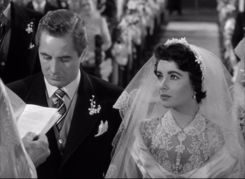 Movie still from “Father of the Bride” (1950), directed by Vincente Minnelli – A man and a woman are standing in front of a group of people; Close Up shot, Over the shoulder angle