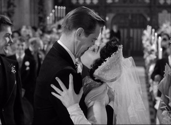 Movie still from “Father of the Bride” (1950), directed by Vincente Minnelli – A man and a woman kissing each other in front of a crowd; Close Up shot, Low angle