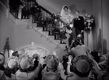 Movie still from “Father of the Bride” (1950), directed by Vincente Minnelli – A black and white photo of a bride and groom on their wedding day; Wide shot, High angle
