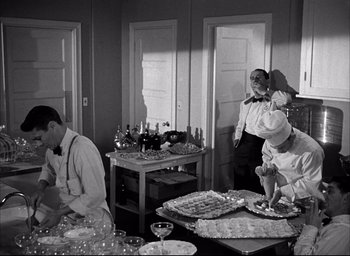 Movie still from “Father of the Bride” (1950), directed by Vincente Minnelli – A black and white photo of people preparing food; Medium shot, High angle