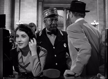 Movie still from “Father of the Bride” (1950), directed by Vincente Minnelli – An old photo of a man and a woman talking to another man; Medium shot, Low angle