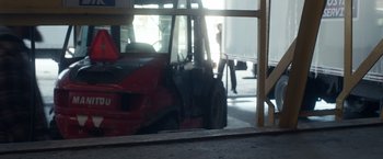 Movie still from “Fatman” (2020), directed by Ian Nelms – A forklift parked in front of a window; Wide shot, Low angle