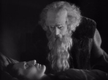 Movie still from “Faust” (1926), directed by F.W. Murnau – An old man with long white beard looking down at a young man; Close Up shot, High angle