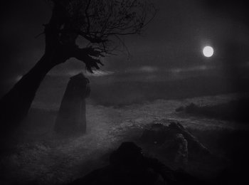 Movie still from “Faust” (1926), directed by F.W. Murnau – A person holding an umbrella standing in the dark; Wide shot, Low angle