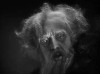 Movie still from “Faust” (1926), directed by F.W. Murnau – An old man with long white hair and a beard; Close Up shot, Low angle