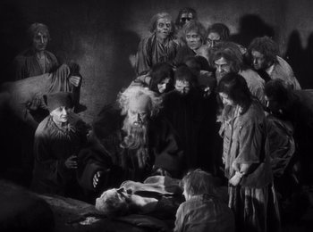 Movie still from “Faust” (1926), directed by F.W. Murnau – A group of people gathered around a dead body; Wide shot, High angle
