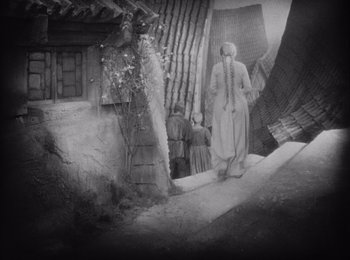 Movie still from “Faust” (1926), directed by F.W. Murnau – An old photo of a woman walking down the street; Wide shot, High angle