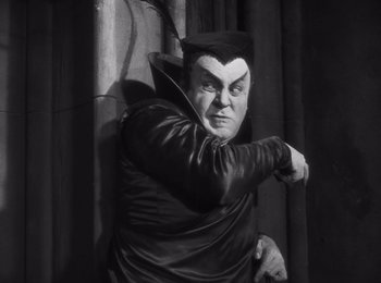 Movie still from “Faust” (1926), directed by F.W. Murnau – A man dressed as a vampire in a black outfit; Medium shot, Low angle