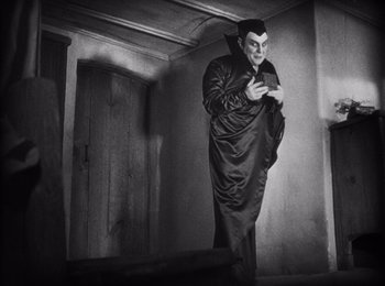 Movie still from “Faust” (1926), directed by F.W. Murnau – A black and white photo of a man dressed as dracula; Wide shot, Low angle