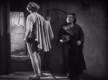 Movie still from “Faust” (1926), directed by F.W. Murnau – Two men dressed in costumes in an old photo; Medium shot, Over the shoulder angle