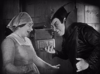 Movie still from “Faust” (1926), directed by F.W. Murnau – An old photo of a man and a woman playing a game; Medium shot, High angle