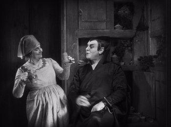 Movie still from “Faust” (1926), directed by F.W. Murnau – An older woman and a younger man in a black and white photo; Medium shot, High angle