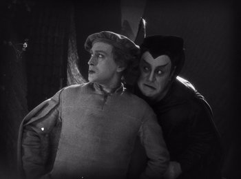 Movie still from “Faust” (1926), directed by F.W. Murnau – A man and a woman dressed in costumes; Medium shot, High angle