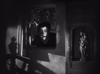 Movie still from “Faust” (1926), directed by F.W. Murnau – A man looking out of a window at a statue; Medium shot, Low angle