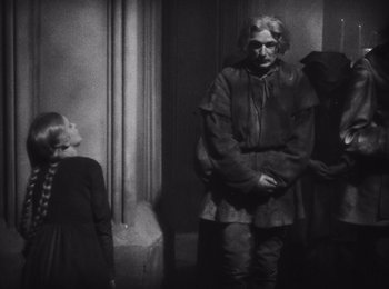 Movie still from “Faust” (1926), directed by F.W. Murnau – A man and a woman standing next to each other in a room; Medium shot, Low angle