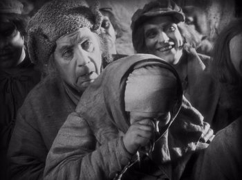 Movie still from “Faust” (1926), directed by F.W. Murnau – A group of people sitting in front of each other; Medium shot, High angle