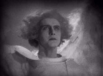 Movie still from “Faust” (1926), directed by F.W. Murnau – A black - and - white photo of a man in a white shirt; Close Up shot, Low angle