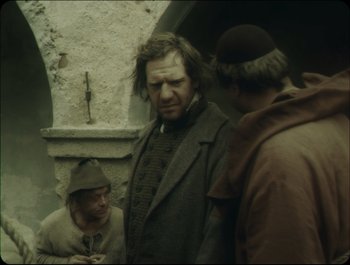 Movie still from “Faust” (2011), directed by Aleksandr Sokurov – A group of men standing next to each other on a street; Medium shot, Over the shoulder angle