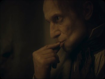 Movie still from “Faust” (2011), directed by Aleksandr Sokurov – A person holding his hand to his mouth; Close Up shot, Over the shoulder angle