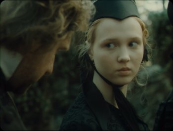 Movie still from “Faust” (2011), directed by Aleksandr Sokurov – A young woman wearing a hat and a black jacket; Close Up shot, Over the shoulder angle