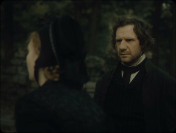 Movie still from “Faust” (2011), directed by Aleksandr Sokurov – A man and a woman are standing in front of each other; Medium shot, Over the shoulder angle