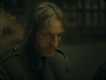Movie still from “Faust” (2011), directed by Aleksandr Sokurov – A person wearing a military uniform; Close Up shot, Over the shoulder angle