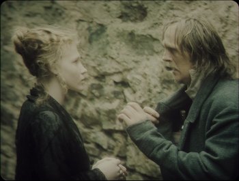 Movie still from “Faust” (2011), directed by Aleksandr Sokurov – A man and a woman standing next to each other; Close Up shot, Over the shoulder angle