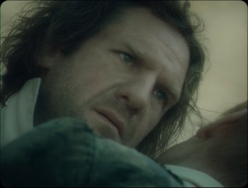 Movie still from “Faust” (2011), directed by Aleksandr Sokurov – A person with long dark hair; Close Up shot, Over the shoulder angle