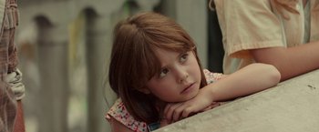 Movie still from “The Shack” (2017), directed by Stuart Hazeldine – A little girl sitting at a table with her head resting on her hand; Close Up shot, Over the shoulder angle