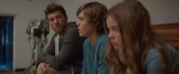 Movie still from “The Shack” (2017), directed by Stuart Hazeldine – A man and two young boys sitting next to each other; Close Up shot, Over the shoulder angle