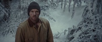 Movie still from “The Shack” (2017), directed by Stuart Hazeldine – A man wearing a hat standing next to a snowy forest; Close Up shot, Over the shoulder angle
