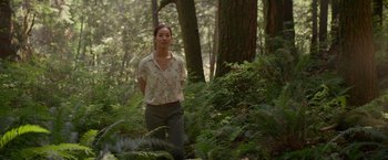 Movie still from “The Shack” (2017), directed by Stuart Hazeldine – A woman standing in the middle of a lush green forest; Wide shot, Over the shoulder angle