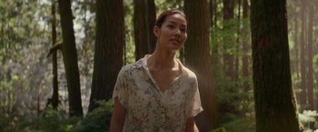 Movie still from “The Shack” (2017), directed by Stuart Hazeldine – A woman standing in the woods wearing a floral shirt; Medium shot, Low angle