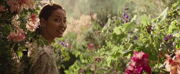 Movie still from “The Shack” (2017), directed by Stuart Hazeldine – A young woman smiling in a garden of flowers; Medium shot, Over the shoulder angle