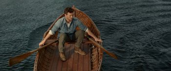 Movie still from “The Shack” (2017), directed by Stuart Hazeldine – A man sitting in a boat on the water; Wide shot, High angle