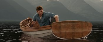 Movie still from “The Shack” (2017), directed by Stuart Hazeldine – A man in a wooden boat in the water; Medium shot, Low angle
