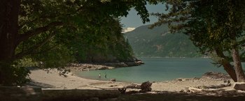 Movie still from “The Shack” (2017), directed by Stuart Hazeldine – Two people walking on a beach near a body of water; Extreme Wide shot, High angle
