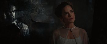 Movie still from “The Shack” (2017), directed by Stuart Hazeldine – A woman in a white dress standing in front of a stone wall; Close Up shot, Over the shoulder angle