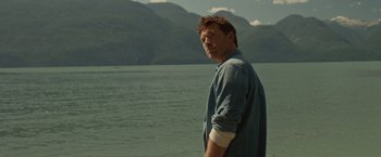 Movie still from “The Shack” (2017), directed by Stuart Hazeldine – A man standing in front of a body of water; Medium shot, Over the shoulder angle