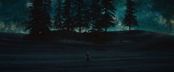 Movie still from “The Shack” (2017), directed by Stuart Hazeldine – A man standing in a field at night with trees in the background; Extreme Wide shot, Low angle