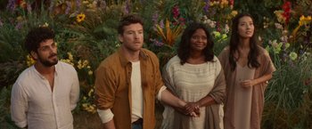 Movie still from “The Shack” (2017), directed by Stuart Hazeldine – A man and a woman standing next to each other in front of flowers; Medium shot, Over the shoulder angle