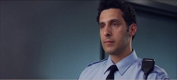 Movie still from “Fear X” (2003), directed by Nicolas Winding Refn – A person wearing a suit and tie; Close Up shot, Low angle