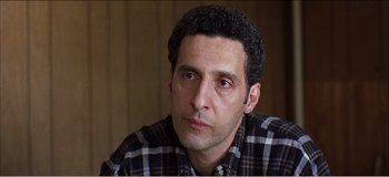 Movie still from “Fear X” (2003), directed by Nicolas Winding Refn – A person wearing a plaid shirt; Close Up shot, Low angle