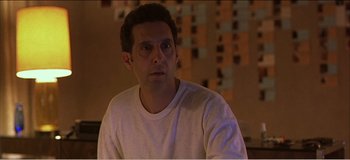 Movie still from “Fear X” (2003), directed by Nicolas Winding Refn – A person wearing a white t - shirt; Close Up shot, High angle