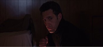 Movie still from “Fear X” (2003), directed by Nicolas Winding Refn – A person in a dark room; Close Up shot, Low angle