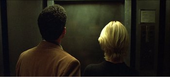 Movie still from “Fear X” (2003), directed by Nicolas Winding Refn – Two people are looking into a lift; Close Up shot, Low angle