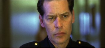 Movie still from “Fear X” (2003), directed by Nicolas Winding Refn – A person wearing a police uniform; Close Up shot, Low angle