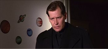 Movie still from “Fear X” (2003), directed by Nicolas Winding Refn – A man in a suit and tie looking at the camera; Close Up shot, Low angle